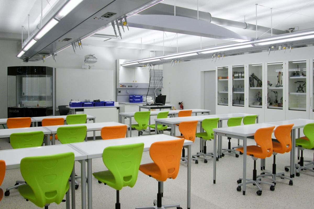 Schulmöbel Referenzen Schule Flums Technikzimmer ergonomische Bildungseinrichtung Stühle auf Rollen orange und grün L+S AG design + technics